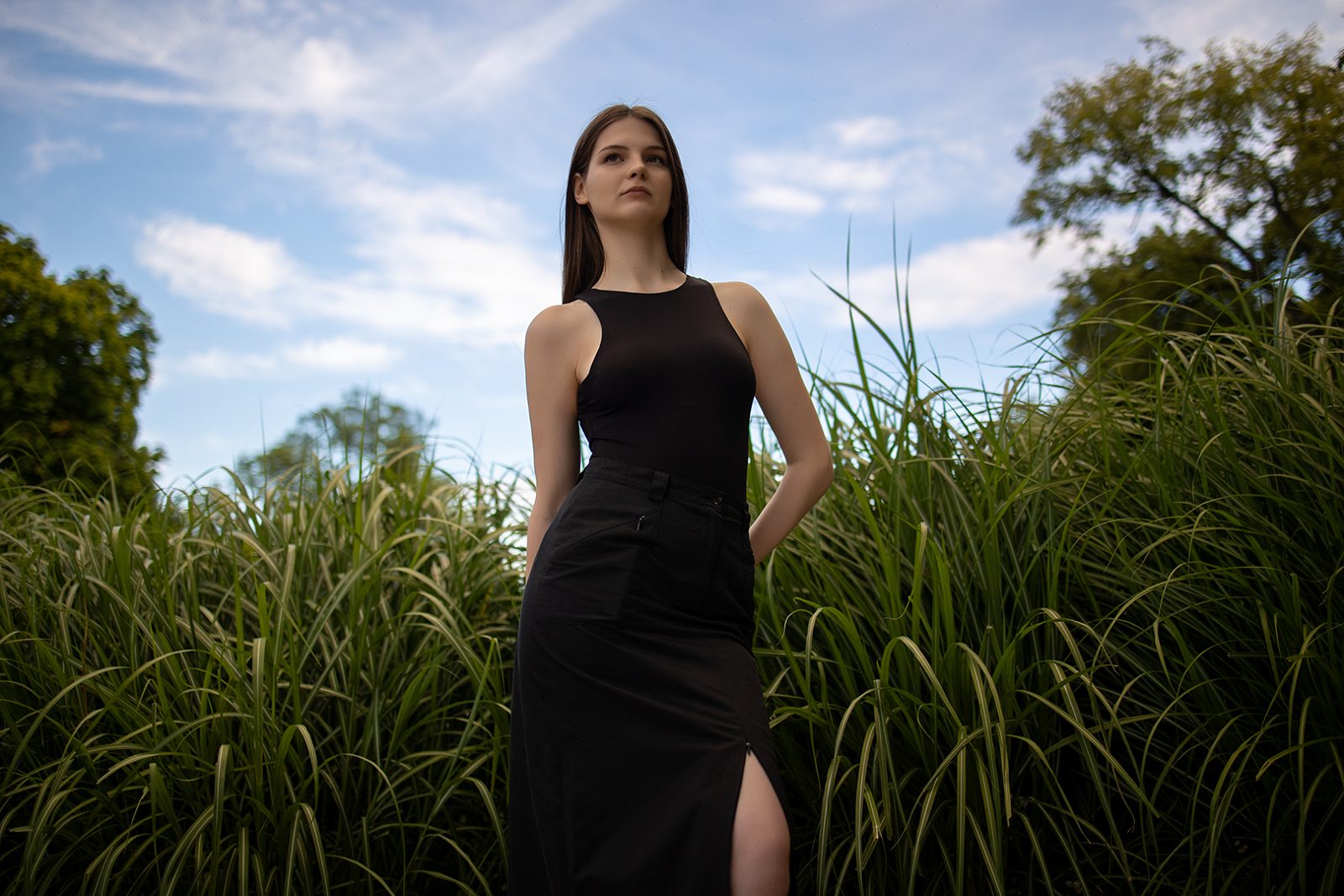 Woman in a black dress among tall grass