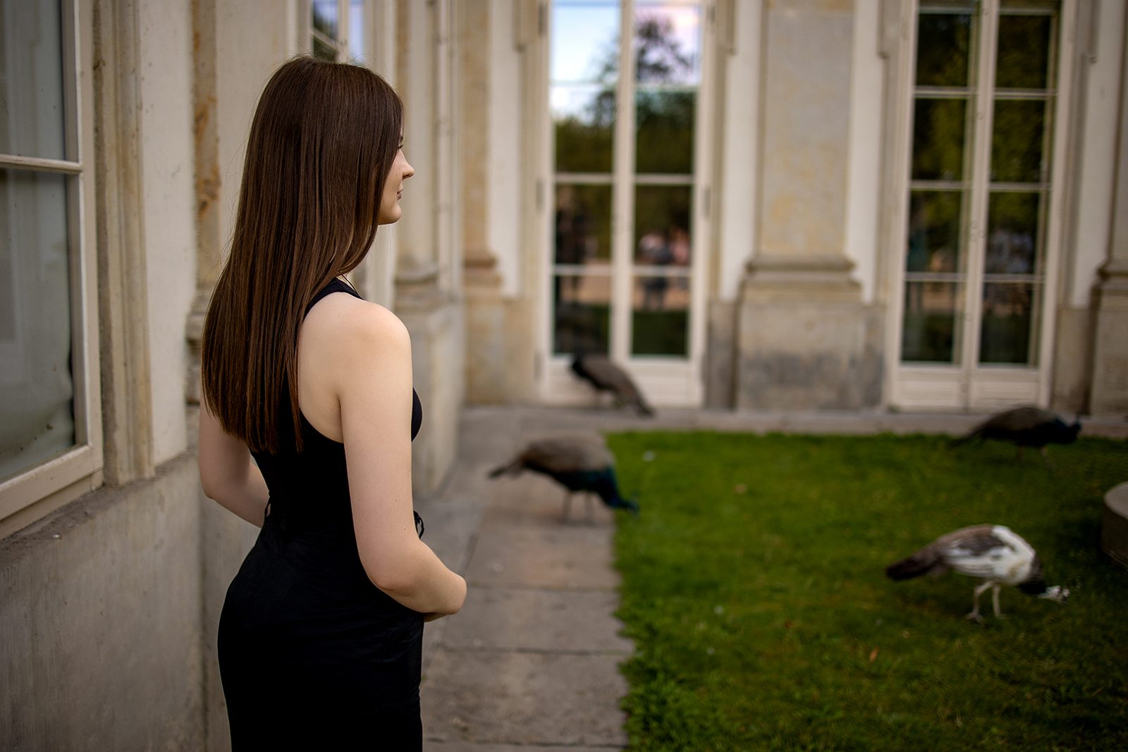 Woman in a black dress in a manor courtyard
