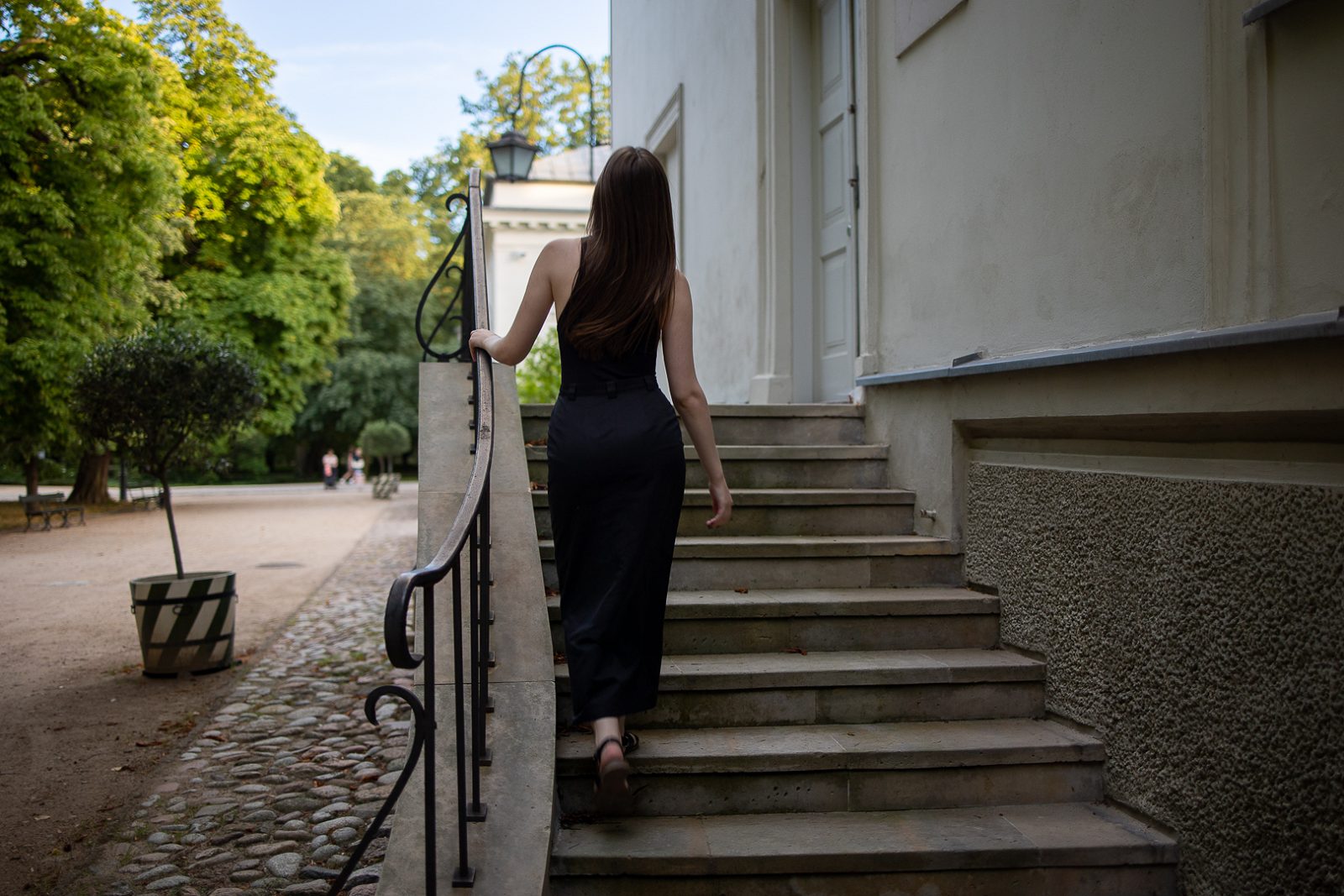Woman in a black dress walking up stone steps