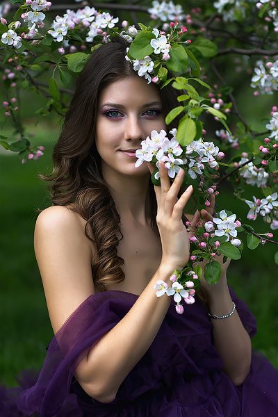 Portrait of a woman with a blooming apple branch