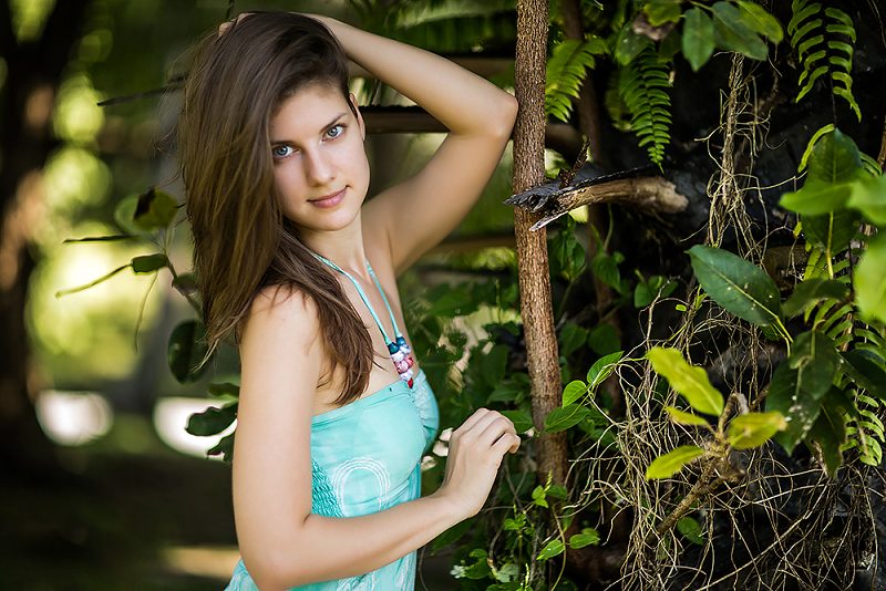 Portrait of a woman in a blue dress among vines