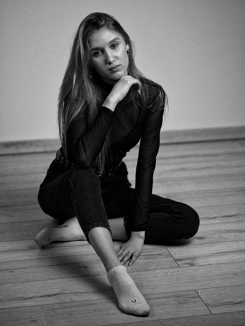 Black-and-white portrait of a woman sitting on the floor