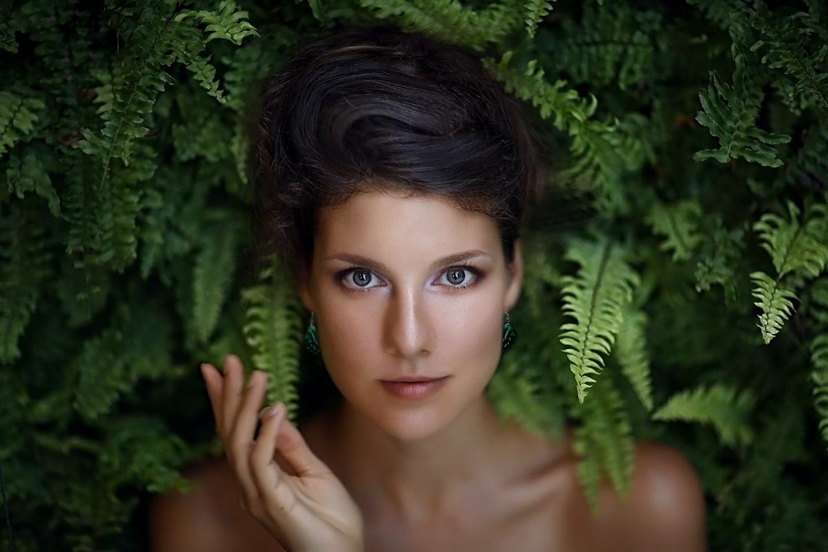 Portrait of a woman among fern leaves