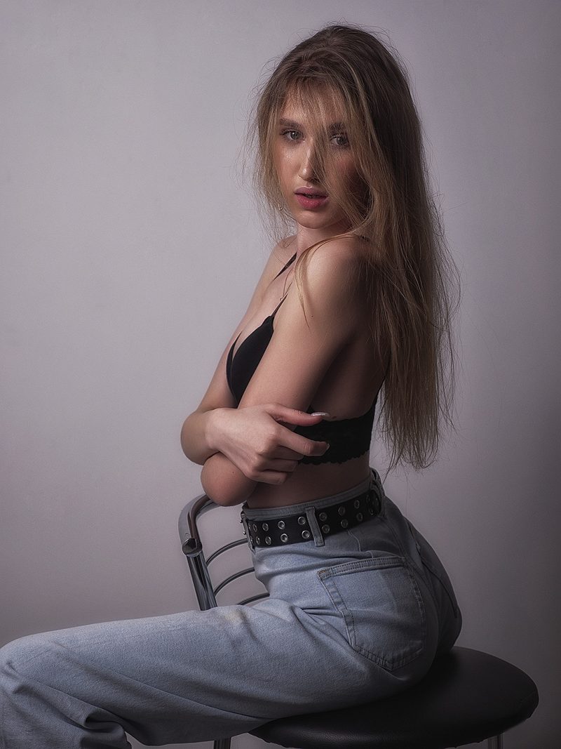 Studio portrait of a woman in a black top and jeans