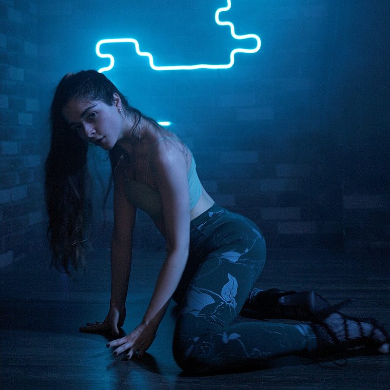 Woman kneeling in blue neon light